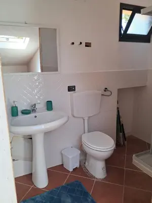 a small bathroom with a toilet and a sink at Al ventitré Home in Trabia