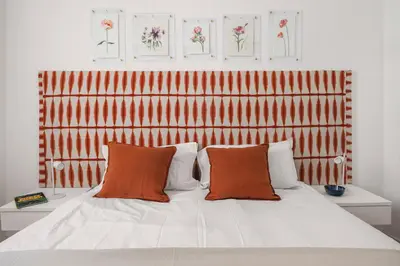 a bed with two orange pillows on top of it at Giada's House By DomuSicily in Palermo