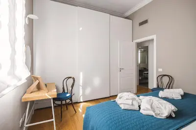 two beds in a room with a table and chairs at Giada's House By DomuSicily in Palermo
