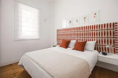 a bedroom with a large white bed with orange pillows at Giada's House By DomuSicily in Palermo