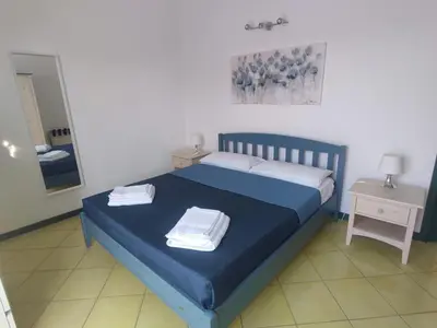 a bedroom with a blue bed with towels on it at Casa di Lolli in San Vito lo Capo