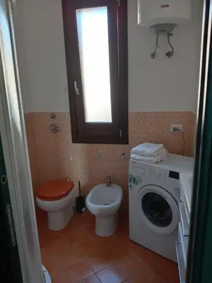 a bathroom with a toilet and a washing machine at Casa di Lolli in San Vito lo Capo