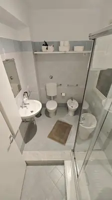 a bathroom with two toilets and a sink and a mirror at Profumo di casa 2 in Lascari