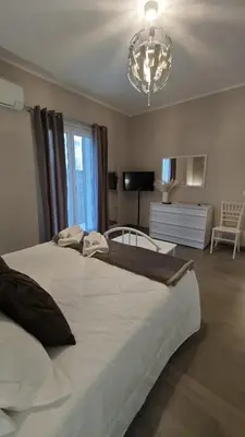 a bedroom with a large white bed and a chandelier at Profumo di casa 2 in Lascari