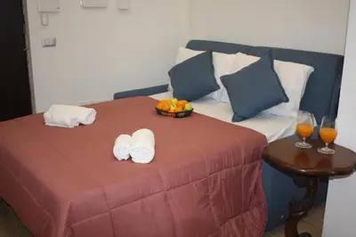 a bed with a bowl of fruit and two glasses of orange juice at Sapphire Home in Palermo