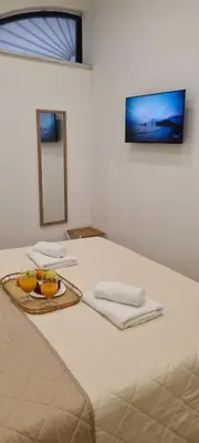a white bed with two bowls of fruit on it at Sapphire Home in Palermo