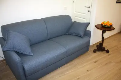 a blue couch in a living room with a table at Sapphire Home in Palermo