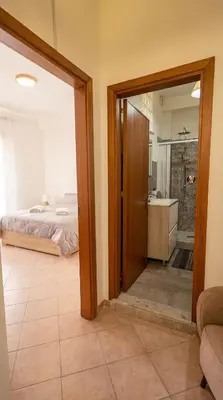 a bedroom with a bed and a bathroom with a mirror at Apollo Apartment in Palermo