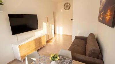 a living room with a couch and a tv on a wall at Apollo Apartment in Palermo