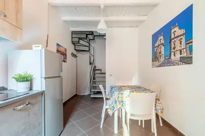 a kitchen and dining room with a table and a refrigerator at Casa Peppa by Wonderful Italy in Palermo
