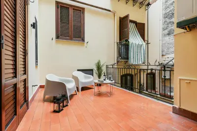 an outdoor patio with white chairs and a fireplace at Dimora d'incanto al Capo in Palermo