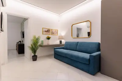a blue couch in a living room with a mirror at Dimora d'incanto al Capo in Palermo