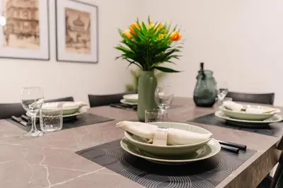 a table with plates and glasses and a vase with flowers at Dimora d'incanto al Capo in Palermo