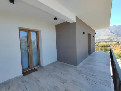 an empty room with a balcony with mountains in the background at Brezza Marina in Alcamo