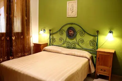 a green bedroom with a bed and two night stands at Villetta Gelsomini, San Vito Lo Capo in San Vito lo Capo