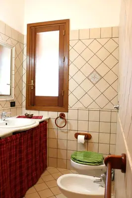 a bathroom with a toilet and a sink and a mirror at Villetta Gelsomini, San Vito Lo Capo in San Vito lo Capo