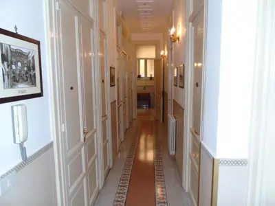 a long hallway with white walls and a long floor at Albergo Cavour in Palermo