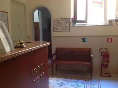 a bedroom with a bed with a yellow comforter at Albergo Cavour in Palermo