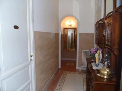 a hallway with a door and a table and a mirror at Albergo Cavour in Palermo