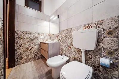 a bathroom with a toilet and a sink at Maison Vulpi in Palermo
