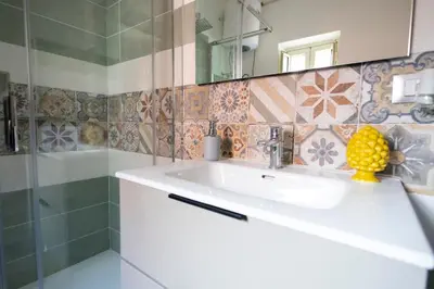a bathroom with a sink and a shower and a mirror at iFlat Casa Sant'Agata in Palermo