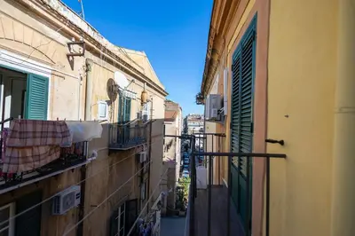 an alley in an italian city with buildings and a balcony at iFlat Casa Sant'Agata in Palermo