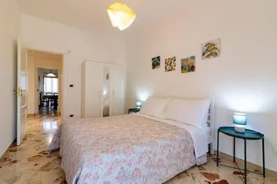 a white bedroom with a bed and two tables at GuestHost - Lovely Flat near Palazzo dei Normanni in Palermo