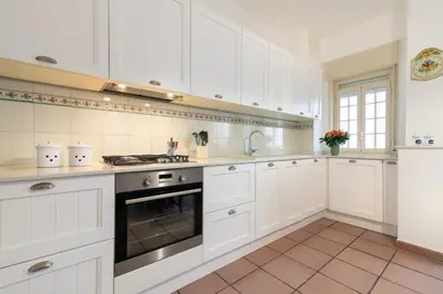 a white kitchen with white cabinets and an oven at GuestHost - Lovely Flat near Palazzo dei Normanni in Palermo