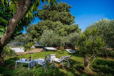 two chairs and a table in a yard at Villa Giummara Cala bianca in Castellammare del Golfo