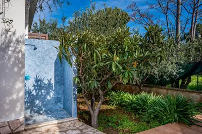 a blue stone monument in front of a tree at Villa Giummara Cala bianca in Castellammare del Golfo
