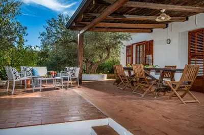 an outdoor patio with a table and chairs at Villa Giummara Cala bianca in Castellammare del Golfo