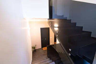 a staircase in a room with a black stair case at Ciuri di Sicilia Apartments in Castellammare del Golfo