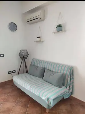 a couch sitting in a room with a wall at La terrazza vent8 in Buonfornello