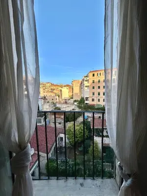 a view of a city from a balcony with curtains at Casa del Teatro in Palermo