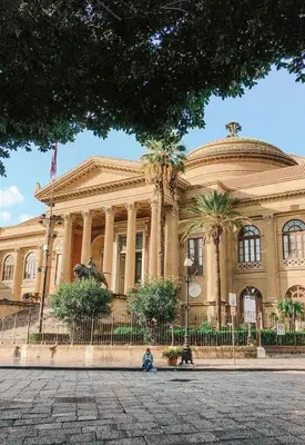 a building with a person sitting in front of it at Auri's home in Palermo