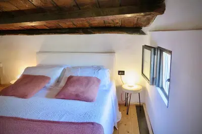 a bedroom with a white bed with two pink pillows at Villa Halcón, casale con piscina tra gli ulivi, vicino al mare tra Balestrate e Alcamo in Partinico