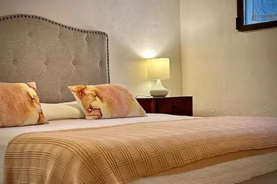 a bed with two pillows and a lamp in a room at Villa Halcón, casale con piscina tra gli ulivi, vicino al mare tra Balestrate e Alcamo in Partinico