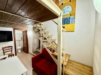 a living room with a staircase and a red couch at Casa del Cortile Secco in Palermo