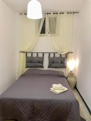 a bedroom with a bed with a robe on it at Delle Palme Holiday Home in Isola delle Femmine