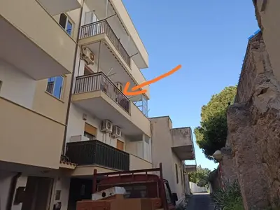 a building with a orange arrow on the side of it at Delle Palme Holiday Home in Isola delle Femmine