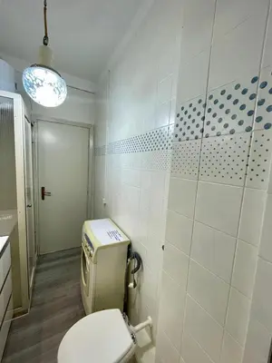 a bathroom with a white toilet in a room at Delle Palme Holiday Home in Isola delle Femmine