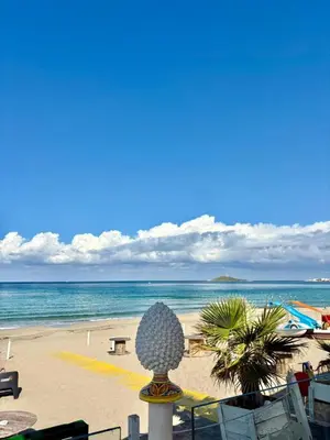 a view of a beach with the ocean and a sculpture at Delle Palme Holiday Home in Isola delle Femmine