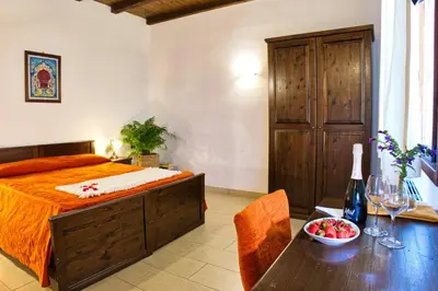 a bedroom with a bed and a table with a bowl of fruit at Agriturismo Case Varisco in Altavilla Milicia