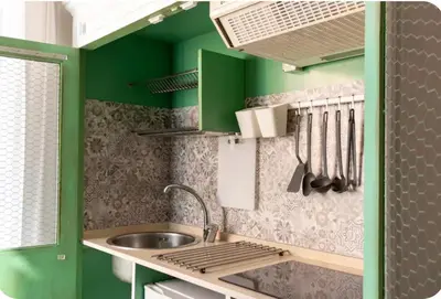 a small kitchen with green walls and a sink at La Luna di Noah al Massimo in Palermo