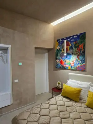 a bedroom with a bed and a painting on the wall at Venticinque Passi - nel cuore di Palermo in Palermo