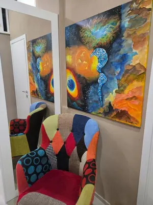 a chair in a room with paintings on the wall at Venticinque Passi - nel cuore di Palermo in Palermo