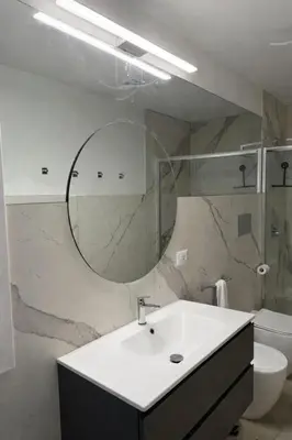 a bathroom with a sink and a mirror and a toilet at Richgood Luxury homes - Villa Zefira sole in Altavilla Milicia