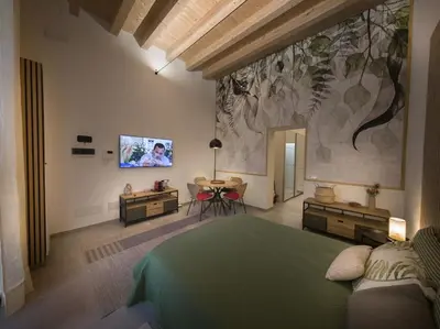 a bedroom with a green bed and a tv on a wall at Bonsai Loft in Palermo