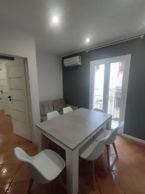a dining room with a table and white chairs at Mumin in Carini