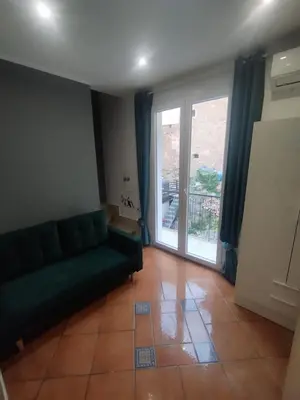 a living room with a couch and a sliding glass door at Mumin in Carini